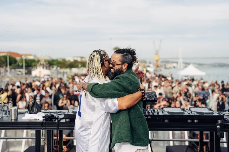 Safar and Moojo embracing at the decks with the crowd behind them