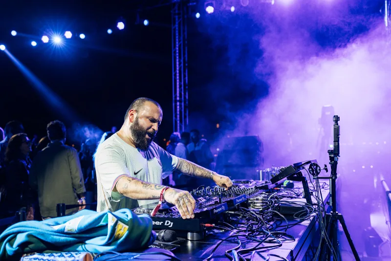 Hvmza performing under purple stage light and haze at night